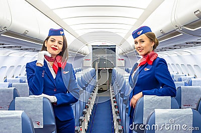 Charming Stewardess Dressed In Uniform in the passenger cabin of the aircraft. Russia, Saint-Petersburg. 23 November, 2017. Editorial Stock Photo