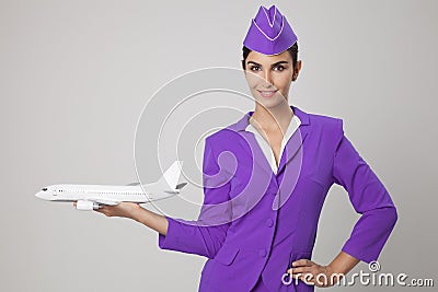 Charming Stewardess Holding Airplane In Hand. Stock Photo