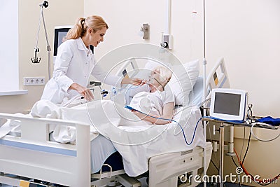 Charming trained doctor taking good care of her patient Stock Photo