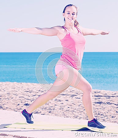 Charming young female exercising on exercise mat outdoor Stock Photo