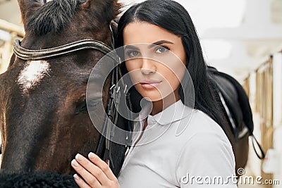 Charming young lady hugging beautiful purebred horse Stock Photo