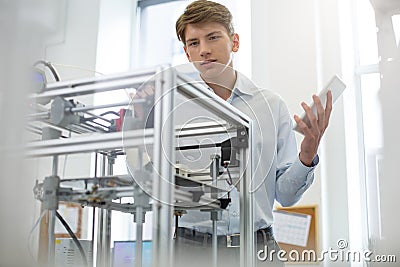 Charming young man learning structure of extruder Stock Photo