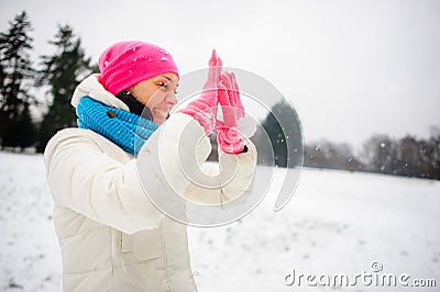 The charming young woman plays with someone in snowballs. Stock Photo