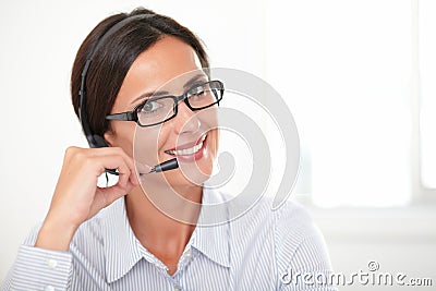 Charming young woman speaking on headphones Stock Photo