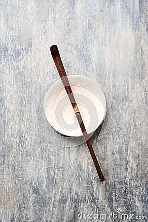 Chashaku Matcha spoon and empty ceramics plate on rustic wooden background. Stock Photo