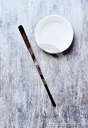 Chashaku Matcha spoon and empty ceramics plate on rustic wooden background. Stock Photo