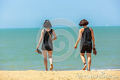 Woman walking at coastline barefoot Editorial Stock Photo