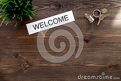 Check in at the hotel. Word welcome near room keys on dark wooden table background top view copyspace Stock Photo