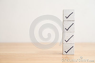 Check mark sign on white block checklist stack on wooden table background copy space. Checklist and questionnaire in business Stock Photo