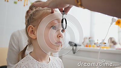Check up of eyesight in child`s ophthalmology - optometrist diagnosis little girl Stock Photo