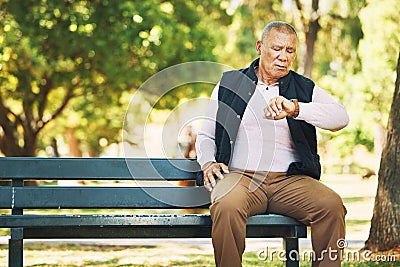 Check, watch and senior man outdoor in nature, park or planning activity in retirement schedule. Reading, time and Stock Photo