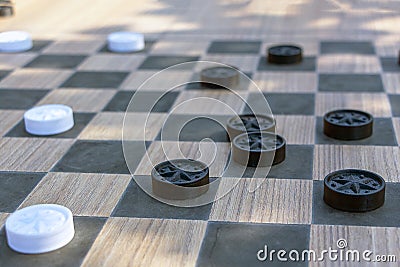 Checkers game made from carved wood. Outdoors board game. Free entertainment for citizens in city park Stock Photo
