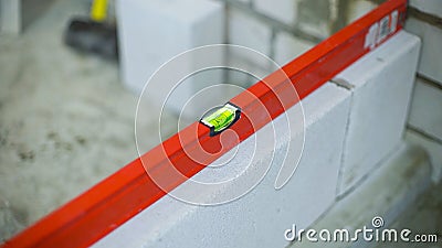 Checking evenness of aerated concrete wall with bubble level Stock Photo