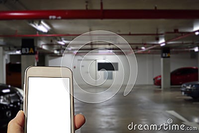 Checking a mobile phone underground in a parking lot. Stock Photo