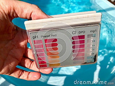 Checking pH level in blue outdoor pool Stock Photo