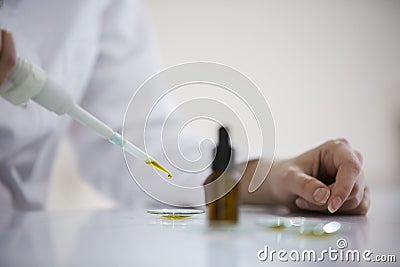 Checking a pharmaceutical cbd oil in a laboratory on watch glass Stock Photo