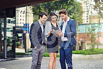 They checking their app for the randevu. businesspeople using a tablet outside. Stock Photo