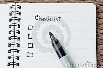 Checklist with marker pen and check box on small notepad on wood table, to do list, prioritize or reminder for project or plan Stock Photo