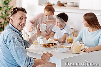 Cheeful man having breakfast with his family Stock Photo