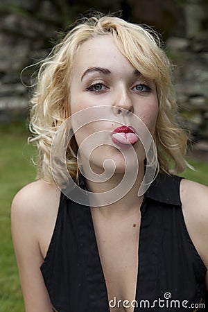 Cheeky blonde teenager pulling tongues Stock Photo