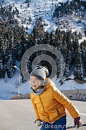 Cheeky perky little girl on a narrow brige holding snowball, wating Stock Photo