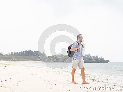 Cheerful adult man with bag having fun on tropical beach Stock Photo