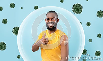 Cheerful african american young guy show shoulder with plaster after vaccination and thumb up Stock Photo