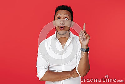 Cheerful african american young man holding finger up over red background. Idea concept. Stock Photo