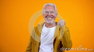 Cheerful aged male showing yes gesture on camera, success, pleasure emotions Stock Photo