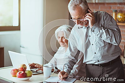 Cheerful aged man talking on smart phone Stock Photo