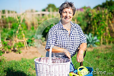 Cheerful aged woman ready to work in home garden Stock Photo