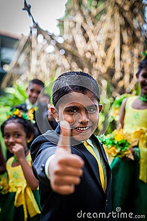 Cheerful Asian boy in a suit shows his thumb up against the background of other children Editorial Stock Photo