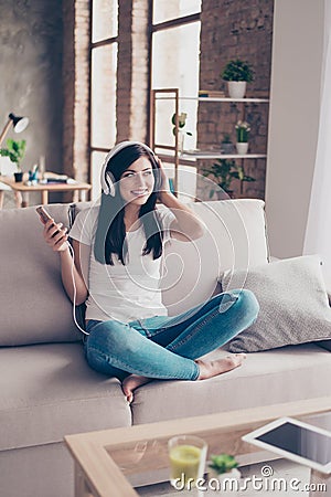 Cheerful attractive brunette teen is listening to music in big w Stock Photo