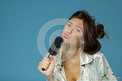 Cheerful attractive teen girl sing song holding comb like a microphone in the morning Stock Photo
