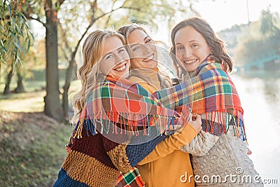 Cheerful attractive three young women best friends having fun together outside. Stock Photo