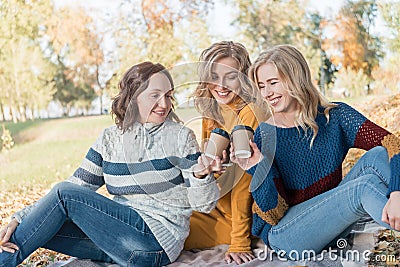 Cheerful attractive three young women best friends having picnic and fun together outside. Stock Photo