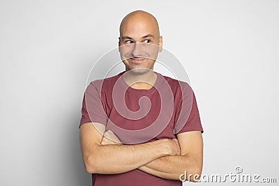 Cheerful bald man is looking away with tricky smile on his face Stock Photo