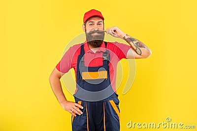 cheerful bearded deliveryman in work clothes on yellow background Stock Photo
