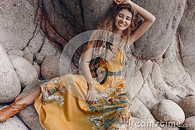 Cheerful beautiful young boho style model on the stone beach Stock Photo