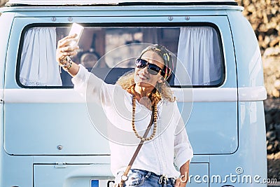 Cheerful beautiful young trendy adult woman take selfie picture smiling and having fun in outdoor leisure with blue vintage Stock Photo