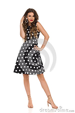 Beautiful Young Woman In Black Cocktail Dress In Polka Dots And Beige High Heels Sandals Stock Photo