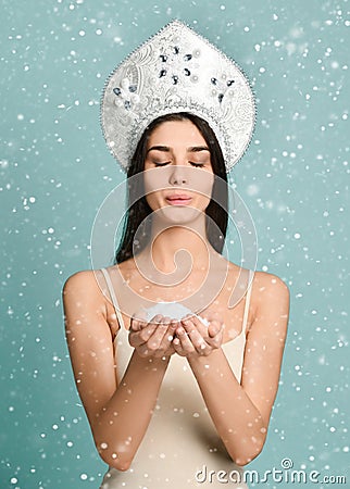 Smiley woman holding snow on blue Stock Photo