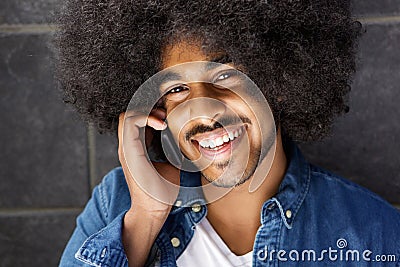 Cheerful black guy using cell phone Stock Photo