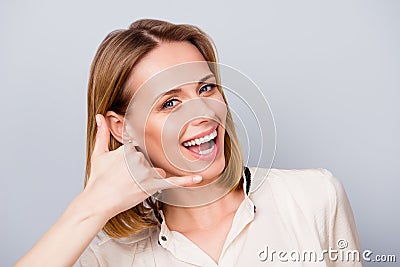 Cheerful blond girl with beaming smile is gesturing to call her Stock Photo