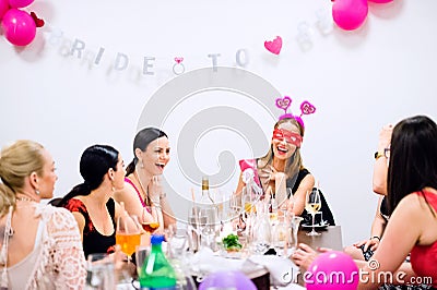 Cheerful bride and bridesmaids celebrating hen party with drinks Stock Photo