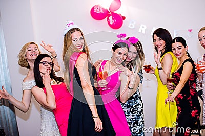 Cheerful bride and bridesmaids celebrating hen party with drinks Stock Photo