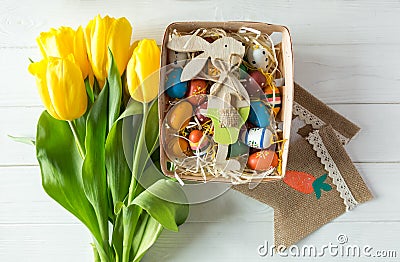 Cheerful, bright, sunny and colorful Easter decorations for home. Everything is ready to celebrate: eggs, flowers, paints, banner Stock Photo