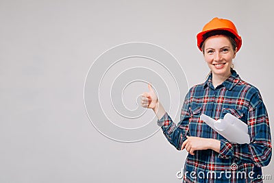 The cheerful builder looks ahead showing a good mood. Thumbs up cool, successful completion of new building Stock Photo