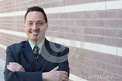 Cheerful businessman with arms folded looking at the camera Stock Photo