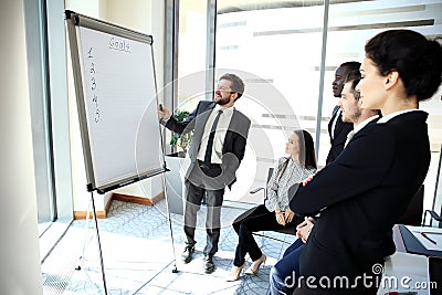 Cheerful businessman discussing new business project with the members of his team Stock Photo